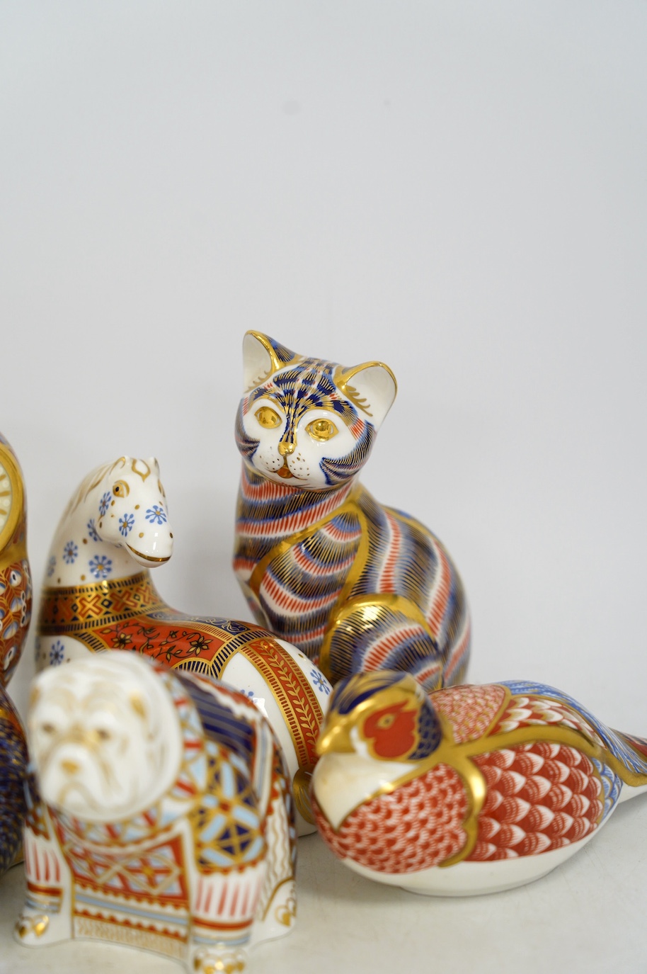 Eight Royal Crown Derby porcelain paperweights in the form of animals including a cat, badger and owl, largest 13.5cm high. Condition - good